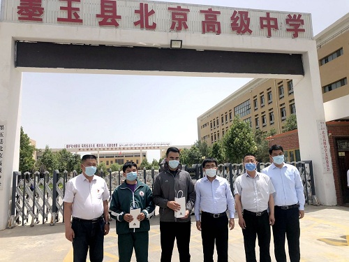 图为:91科技集团许泽玮,赵军与墨玉县北京高级中学师生合影