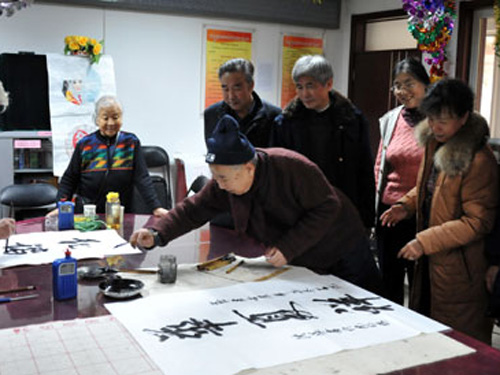 爱好者在社区活动中心举办迎春节书法绘画联