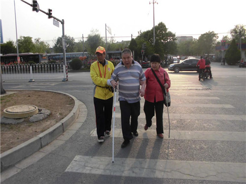 丰台区和义中队引导员 刘东全搀扶盲人过马路(图)
